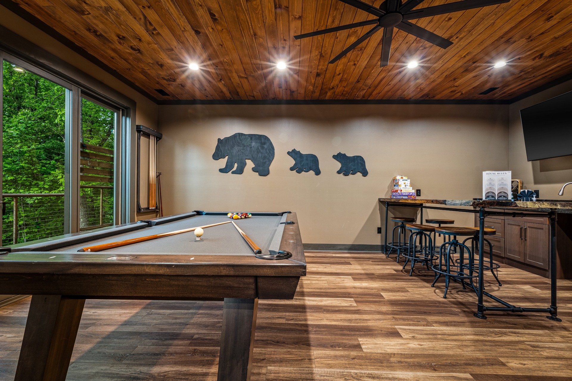 Game room with pool table, bar seating and forest views